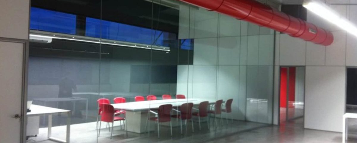 MAMPARA M-ESPACIO TODA DE CRISTAL PARA UNA SALA DE JUNTAS CON DIMENSIONES ESPECIALES SOBRETODO LA ALTURA, ALUMINIO PINTADO EN GRIS Y PUERTAS 203X82X40 EN COLOR BLANCO Y UN FIJO DE MADERA HASTA EL TECHO.